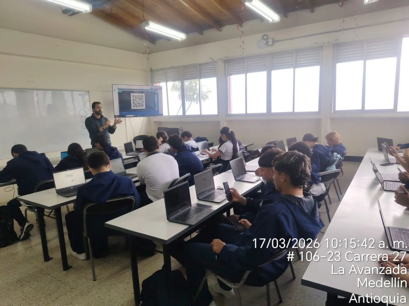David Díaz presentando MELO CREO a estudiantes en una sala de cómputo en Medellín